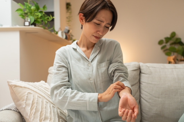 腕の痛みや違和感を気にする女性